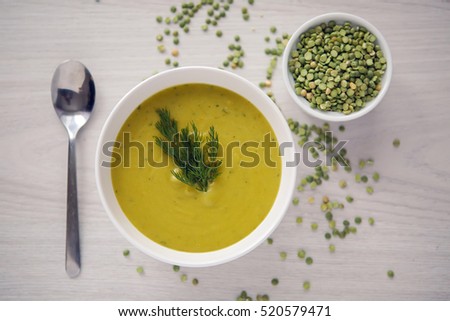pea soup on a wooden table with an iron spoon Royalty-Free Stock Photo #520579471
