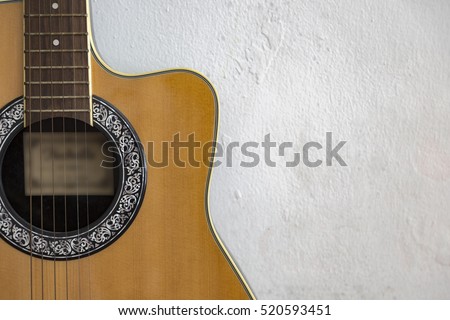 Partial of acoustic guitar isolated on concrete wall background