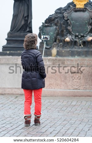 Tourist makes photo on Charles Bridge in Prague, Czechia