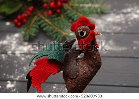 New Year 2017 symbol  - handmade rooster with fir branches and cranberry on gray wooden background