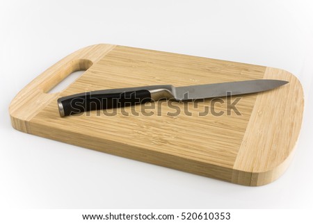 Cutting board with kitchen knife isolated on white background. Picture taken in studio with soft-box.