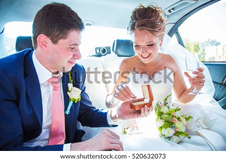 Happy newlyweds ride in wedding limousine