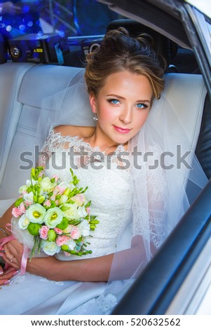 Beautiful, charming bride in  wedding dress sitting in limousine