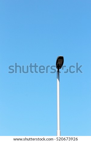 Minimal image of a modern lighting post under blue sky background. Sunny day. Summer