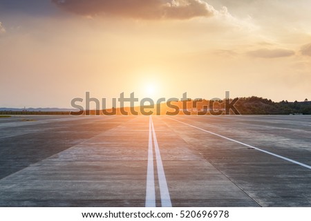 Runway, airstrip in the airport terminal with marking on blue sky with clouds background. Travel aviation concept. Royalty-Free Stock Photo #520696978