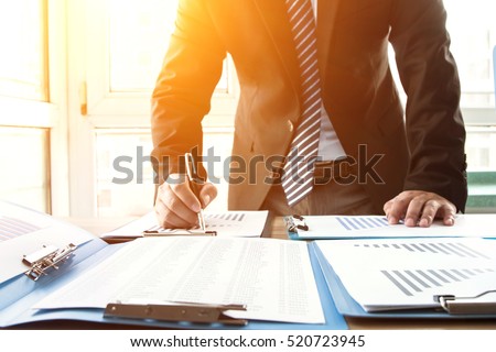 Businessman analyzing financial statements in the office Royalty-Free Stock Photo #520723945