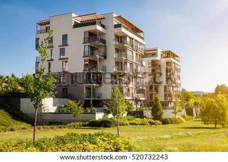 Modern block of flats in the green park. Eco-friendly living in a city. Royalty-Free Stock Photo #520732243