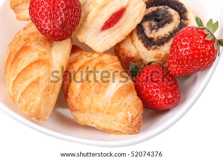 Fresh buns and strawberry on white plate isolated