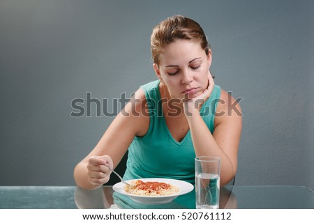 Portrait of woman with no appetite in front of the meal. Concept of loss of appetite Royalty-Free Stock Photo #520761112