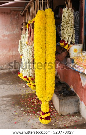 Colorful flower garland jasmine, huge yellow garland of marigold displayed in shop for sale Chennai City, Tamil Nadu/Kerala South India. used for decorating God  temple/churches/for marriage function 