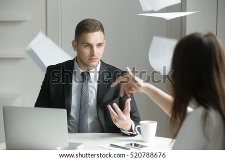Two business people at a heated dispute or argument, the process of negotiation breaks down, misunderstanding, agreement cannot be reached. Woman is throwing papers. Business concept photo Royalty-Free Stock Photo #520788676