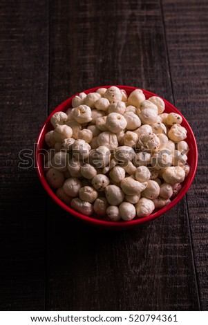 Nutritious roasted Makhana Namkeen or Fox Seed, which is a part of Lotus Flower. Served in a bowl over colourful or wooden background. Selective focus