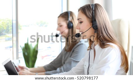Portrait of call center worker accompanied by her team. Smiling customer support operator at work. Royalty-Free Stock Photo #520798177