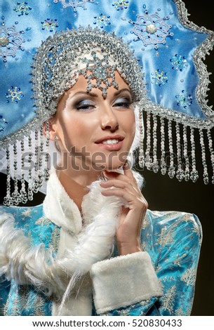 Portrait of a beautiful snow maiden in a crown on the black background 