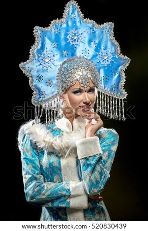 Portrait of a beautiful snow maiden in a crown on the black background
