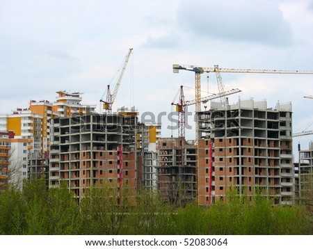 Construction work site place concept with cranes and buildings over sky background