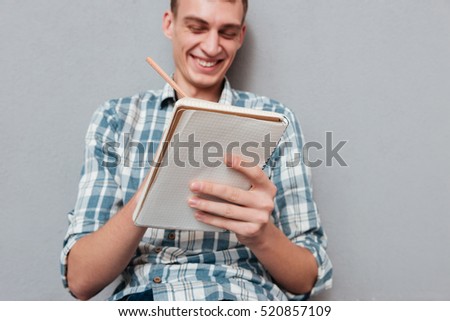 Happy student with notebook. looking at notebook. from below image