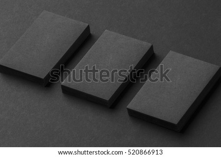 Mockup of three vertical business cards stacks at black textured background.