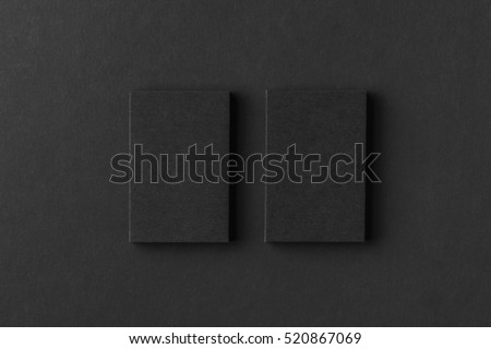 Mockup of two vertical business cards at black textured paper background.