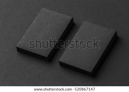 Mockup of two vertical business cards stacks at black textured paper background.