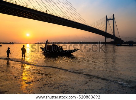 Silhouette sunset on river Hooghly with Vidyasagar setu (bridge) at the backdrop. Photograph taken from Princep Ghat, Kolkata, India.