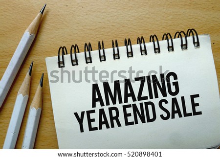 Amazing Year End Sale text written on a notebook with pencils