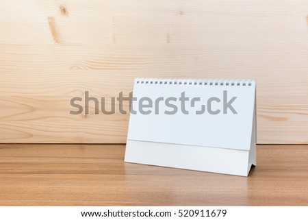 White blank paper desk spiral calendar on wood background. Royalty-Free Stock Photo #520911679