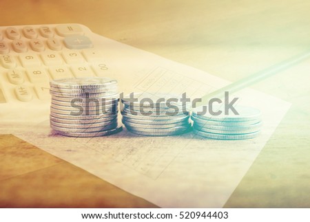 Double exposure stack of coins with utility bill with calculator and pencil, Saving money and account growth finance and banking business concept Royalty-Free Stock Photo #520944403