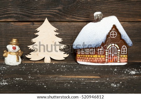 christmas little glass house with snow covered roof, Snowman and Christmas tree on a dark wooden background. Concept of Christmas and New Year.