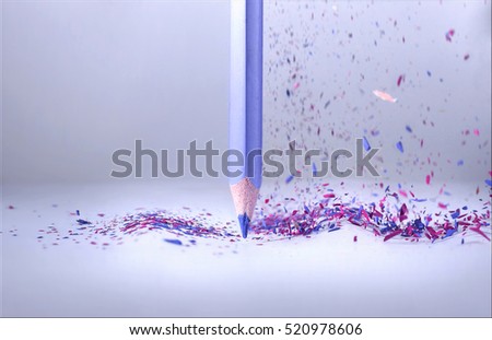 Acute purple blue pencil stands on a piece of paper, shavings fall from top in a free fall. The concept of idea creativity, education, inspiration writer or artist. Vibrant expressive artistic image.