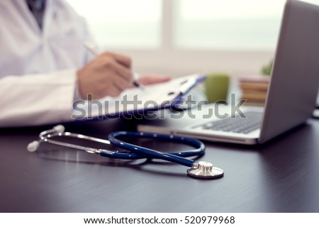 Stethoscope with clipboard and Laptop on desk,Doctor working in hospital writing a prescription, Healthcare and medical concept,test results in background,vintage color,selective focus Royalty-Free Stock Photo #520979968