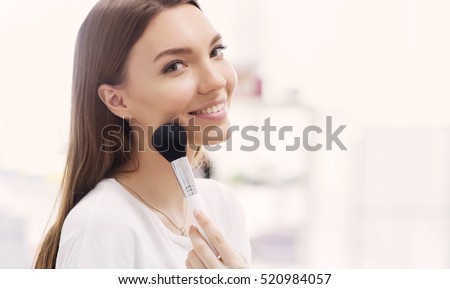 Beautiful girl with cosmetic powder brush for make up. Makeup. Make-up applying  for perfect skin. Royalty-Free Stock Photo #520984057
