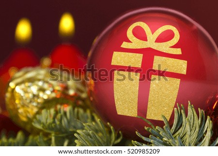 A glossy red bauble with the golden shape of a gift.(series)