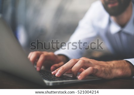 Close up of male hands typing on laptop keyboard