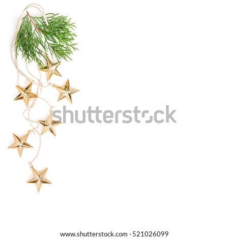 Christmas ornaments on white background. Golden stars decoration with evergreen branches. Minimalistic flat lay