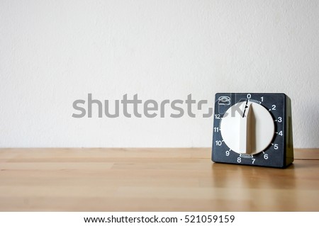 Old vintage retro classic kitchen timer. Wood surface. White wall background and warm autumn natural light.  Royalty-Free Stock Photo #521059159