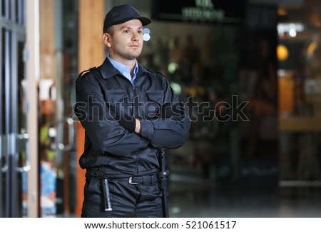 Security man standing indoors Royalty-Free Stock Photo #521061517