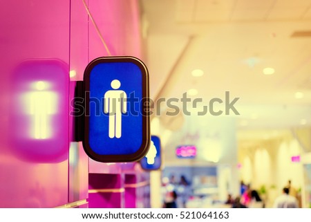 Toilets icon. Blue public restroom signs with a male symbol. Interior of airport terminal.