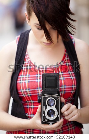 Young female photographer using old 6x6 medium format camera.