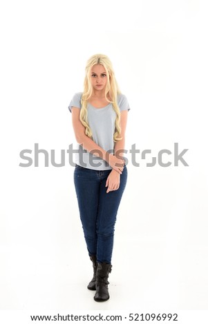 full length portrait of a woman with long blonde hair wearing casual blue shirt and jeans. standing pose. isolated on a white background.