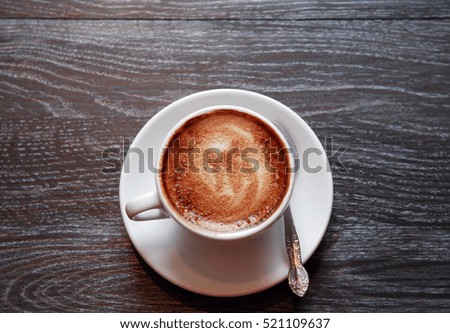 Cup of coffee on dark wooden background with free space