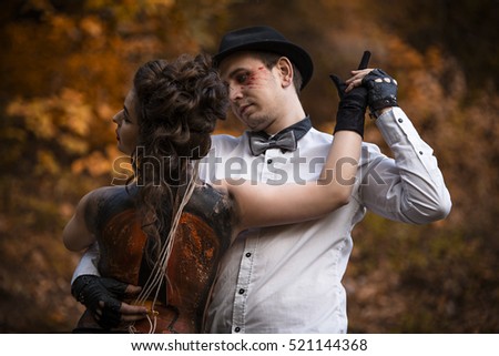 young woman with violin painted on her back held by young man in dancing pose