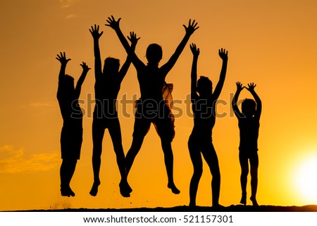 silhouette of five happy jumping kids against sunset
