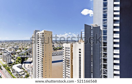 Luxurious city located near beautiful lake and bridge, very attractive place to work and relax, these town buildings are huge also colorful, sky is clear with white clouds.