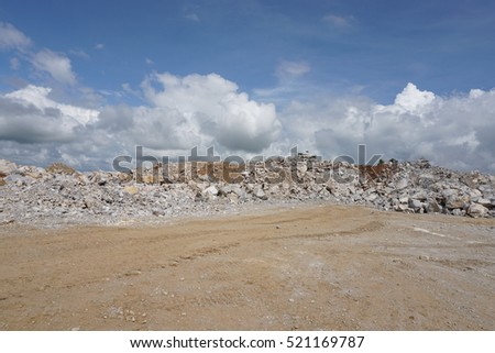 A large pile of limestone rubble against the blue sky.
