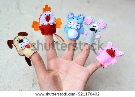 Hand wearing 5 finger puppets: dog, cock, cat, mouse, pig Royalty-Free Stock Photo #521170402