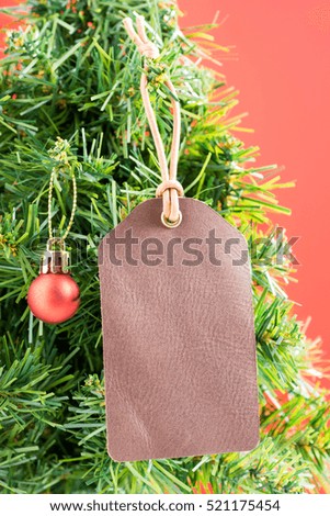 Blank leather label or tag hang on christmas tree with red shading background