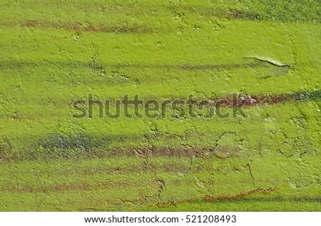 Green and brown peeling paint on concrete wall