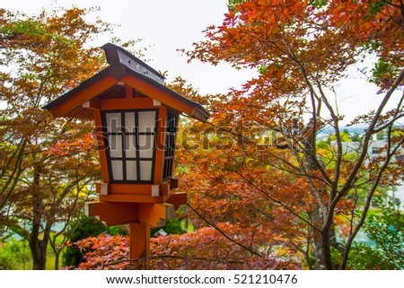 Japanese wooden lantern and bokeh maple leaves autumn background