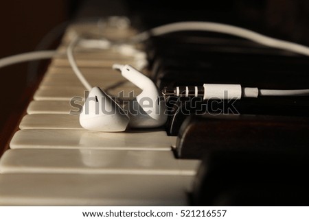 Piano keys with headphones - Stock Image